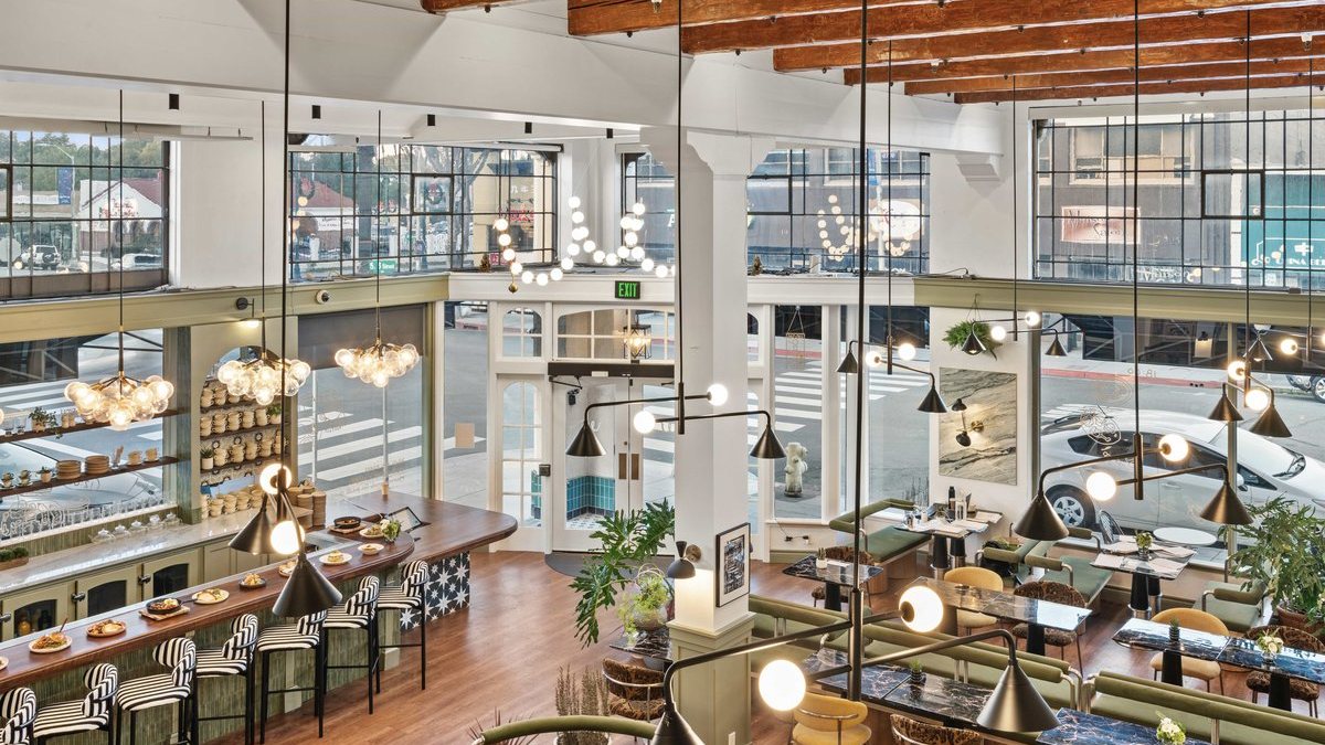Whisper's open room from above, with the bar, green banquettes and tall street-facing windows