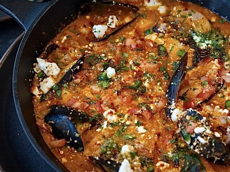 Marrow coast cioppino in a cast iron pan with mussels and feta
